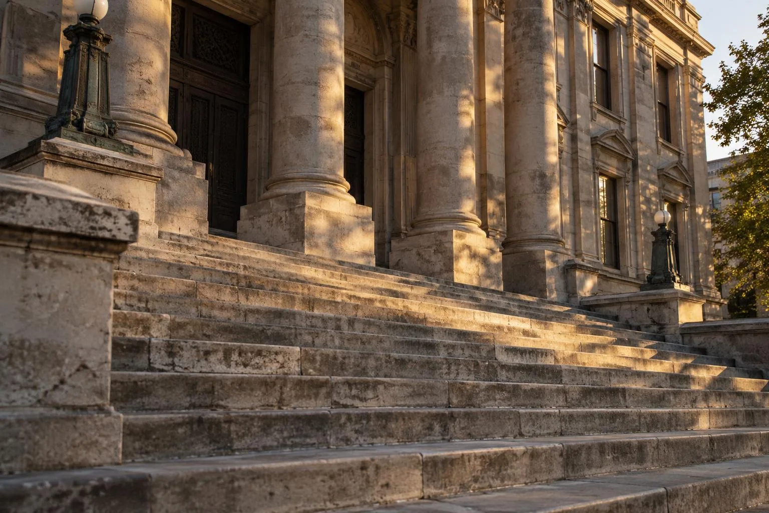 The stone facade and steps of an older civic courthouse in late afternoon light.