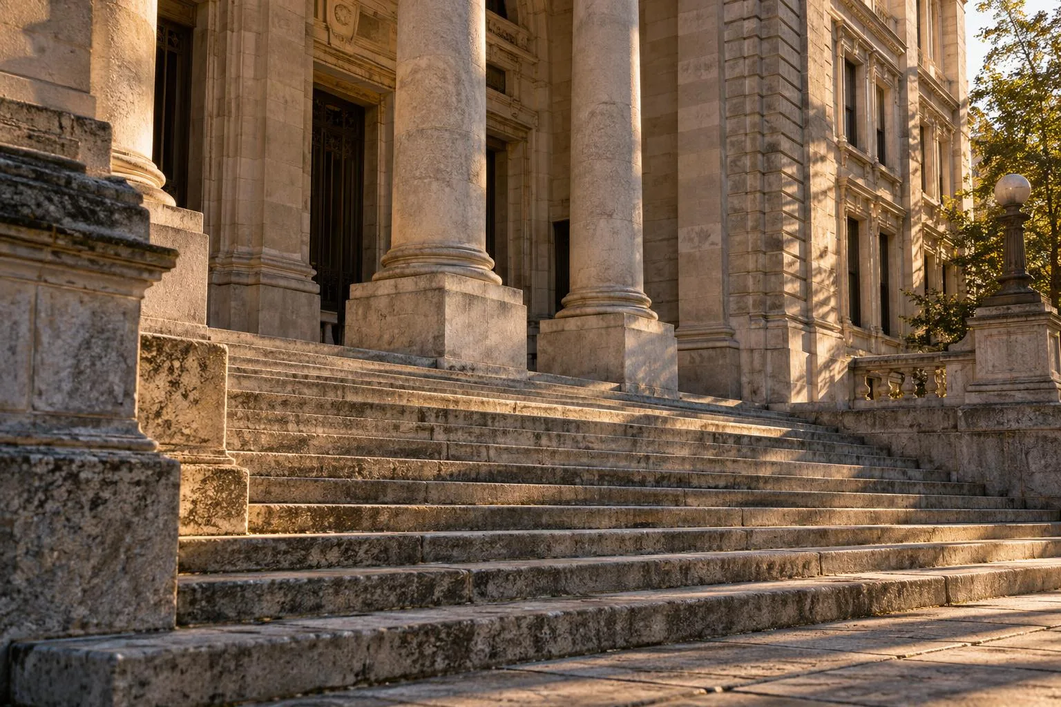 The stone facade and steps of an older civic courthouse in late afternoon light.
